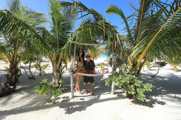 dziewczyna w bikini i facet z palmami na Malediwach