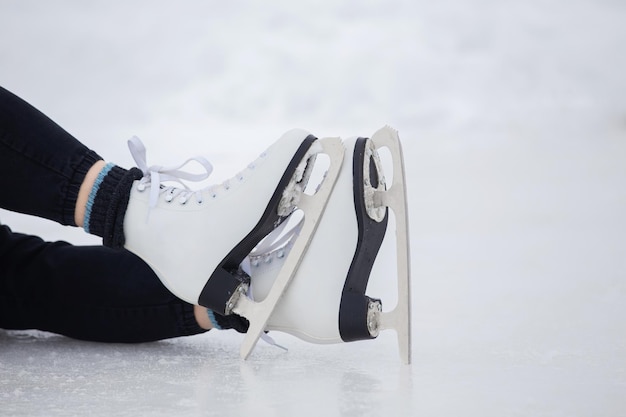 Dziewczyna w czarnych spodniach jeździ na łyżwach po lodzie stadionu w ciągu dnia