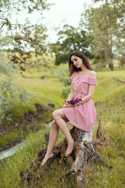 Dziewczyna w czerwonej sukience na naturze latem, Portret pięknej dziewczyny latem w lesie