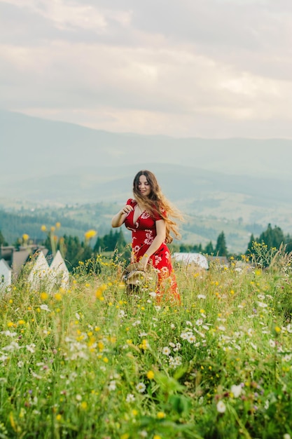 Dziewczyna w czerwonej sukience na spacerze w górzystym terenie
