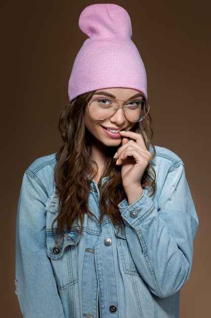 Dziewczyna w dżinsowej kurtce, różowym kapeluszu i stylowych okularach