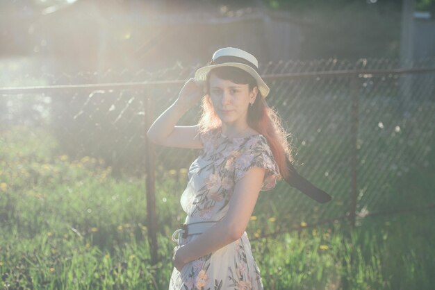 Dziewczyna w kapeluszu i długich włosach o zachodzie słońca i koncepcji widoku z tyłu