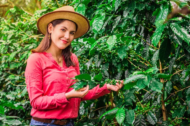 Dziewczyna w kapeluszu i różowej koszuli na plantacji kawy