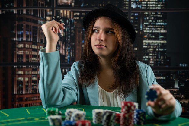Dziewczyna w kasynie gra w pokera z pewnością wygranej kobiety w pokera z kartami