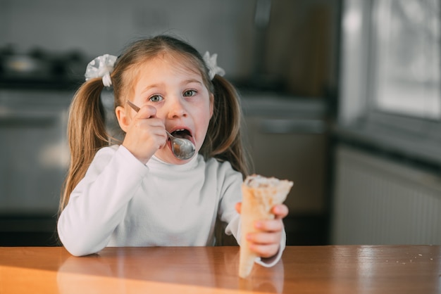 Dziewczyna W Kuchni Jedząca Lody Z łyżką Przy świetle Dnia Bardzo Słodkim