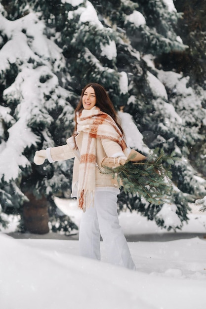 Dziewczyna w lesie zimą z bukietem gałęzi jodły Śnieżna zima