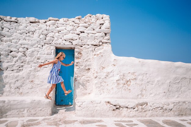 Zdjęcie dziewczyna w niebieskich sukienkach, zabawy na świeżym powietrzu na ulicach mykonos