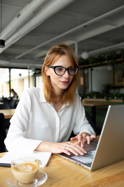 Dziewczyna w okularach pracuje na laptopie