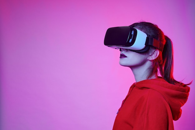 Dziewczyna w okularach VR wybiera opcje podczas doświadczenia w wirtualnej rzeczywistości.