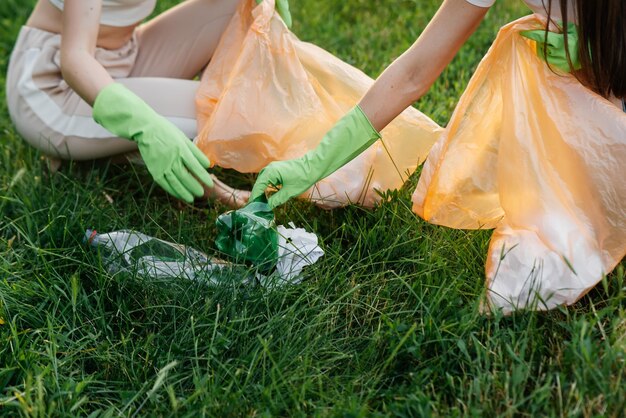 Dziewczyna w parku o zachodzie słońca zajmuje się wywozem śmieci w parku Troska o środowisko recykling odpadów Sortowanie śmieci