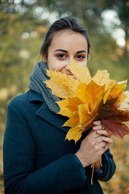 Dziewczyna w płaszczu w lesie jesienią