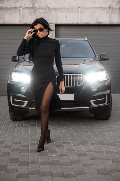 Dziewczyna w pobliżu samochodu w czarnej sukience