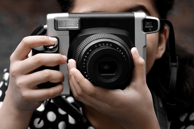 Dziewczyna w sukience polkadot używająca kamery SLR fotografująca osobę robiącą zdjęcie
