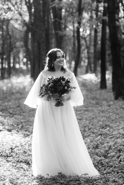 Dziewczyna w sukni ślubnej w jesiennym lesie na tle dzikich drzew