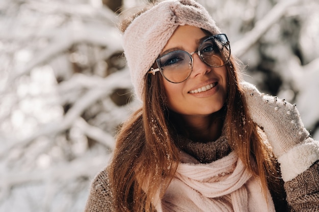 Zdjęcie dziewczyna w swetrze i okularach zimą w zaśnieżonym lesie