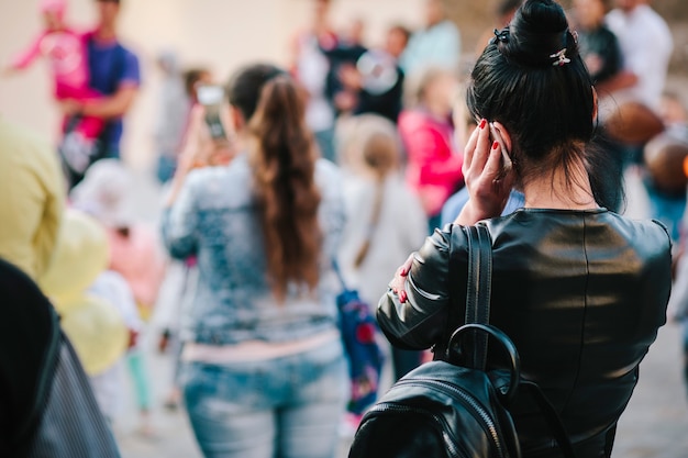 Dziewczyna W Tłumie Używa Telefonu. Zdjęcie Ulicy