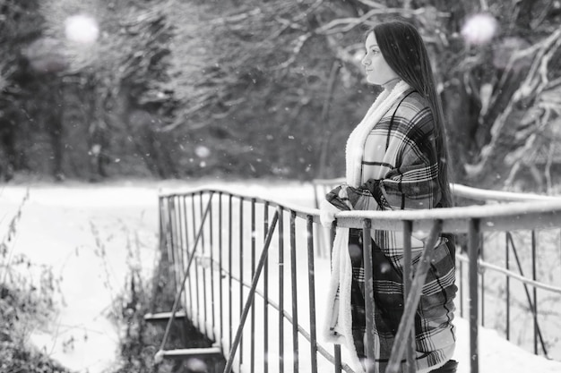 Dziewczyna w zimowy pochmurny dzień pokrytych śniegiem pól i lasów