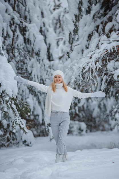 Dziewczyna w zimowym lesie, blondynka, zabawny spacer na łonie natury
