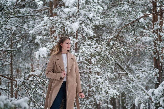 dziewczyna w zimowym lesie z białymi drzewami i obfitym śniegiem