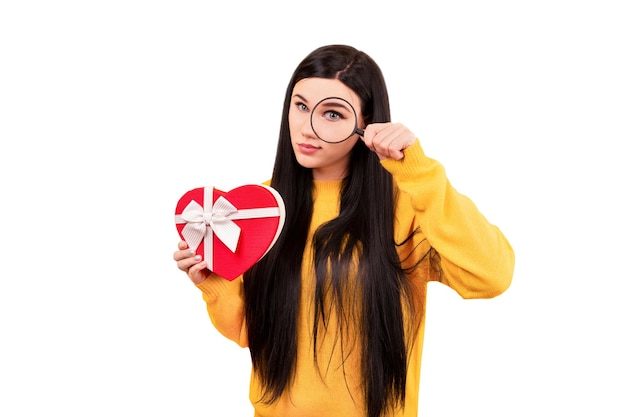 Dziewczyna w żółtym swetrze z prezentem i lupą