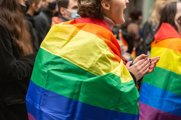 Dziewczyna wspierająca wiec LGBTQ w Kijowie, owinięta tęczową flagą podczas Parady Równości. Koncepcja LGBTQ.