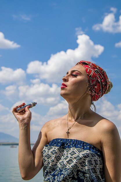 Dziewczyna wypuszcza dym z ust na niebo Koncepcja o niebezpieczeństwach palenia