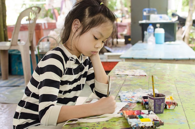 Dziewczyna z Azji rysuje kolorową akwarelę