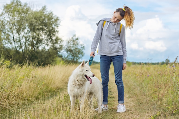 dziewczyna z białym psem, nastolatek chodzenie z husky zwierzaka