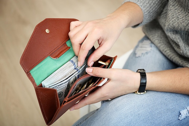 Zdjęcie dziewczyna z brązowym portfelem pełnym pieniędzy