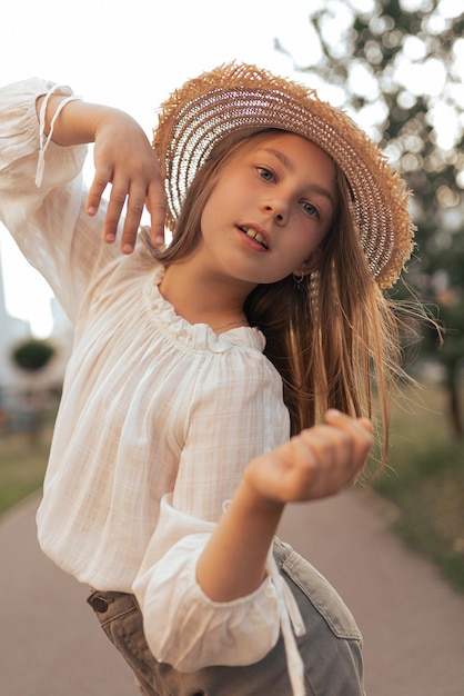 Dziewczyna z długimi włosami i piegami w słomkowym kapeluszu cieszy się życiem i latem