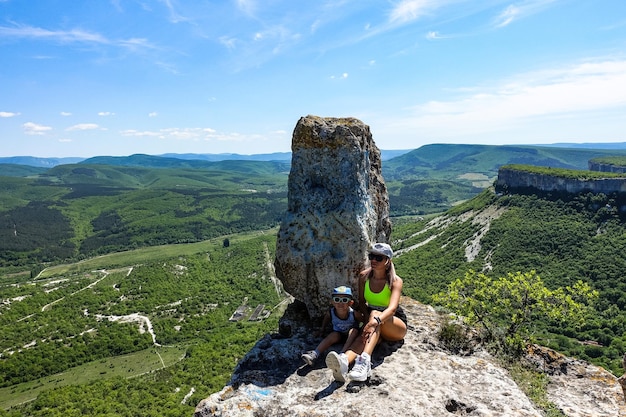 Dziewczyna z dzieckiem na tle widoku na góry krymskie z jaskiniowego miasta TepeKermen Crimea