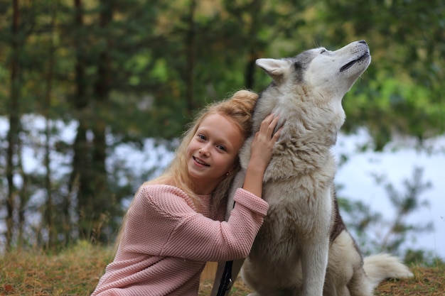 Dziewczyna z husky spaceruje po lesie