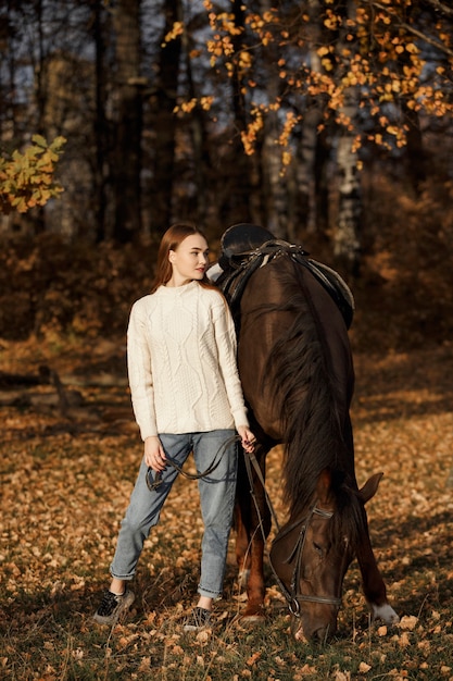 Dziewczyna z koniem na łonie natury, jesienny spacer ze zwierzęciem
