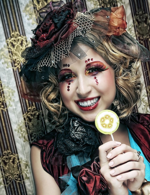 Dziewczyna z kreatywnym makijażem trzyma lizaka