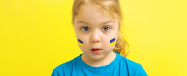 Dziewczyna z namalowaną żółto-niebieską ukraińską flagą na policzkach