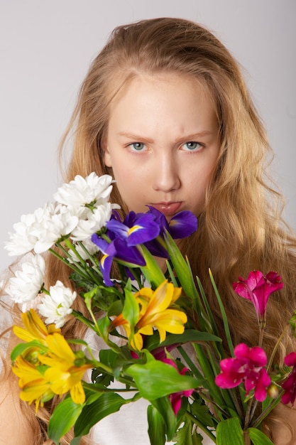Zdjęcie dziewczyna z pięknymi kwiatami w fioletowych ubraniach
