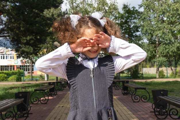 Dziewczyna z plecakiem w pobliżu szkoły po zajęciach nieszczęśliwa zmęczona i ból głowy Dziecko płacze trzymając głowę w dłoniach Niepowodzenia w nauce złe oceny przepracowanie
