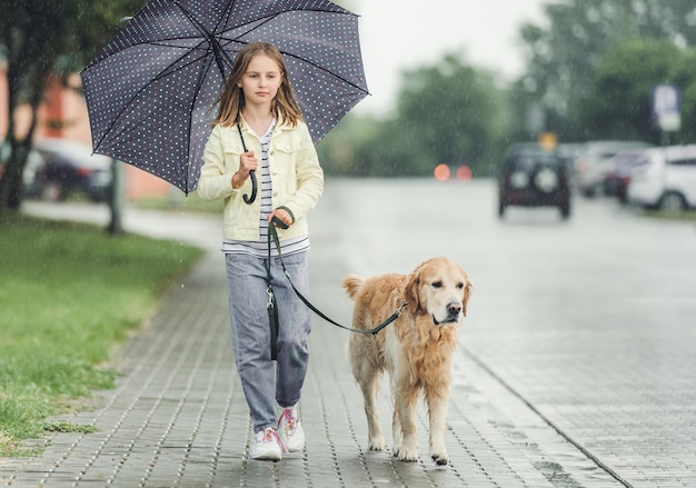 Dziewczyna z psem golden retriever w deszczowy dzień