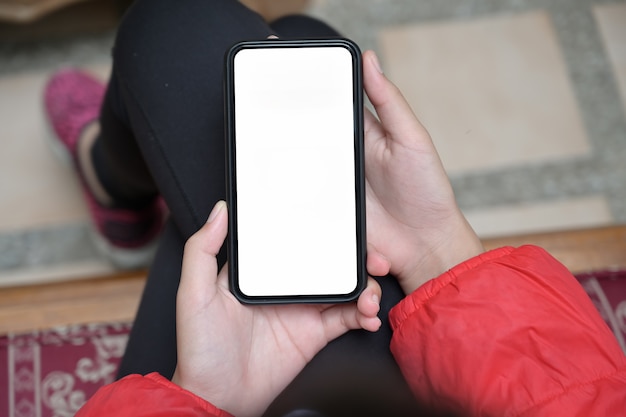 Zdjęcie dziewczyna z pustego ekranu mobilnego smartphone w jej rękach