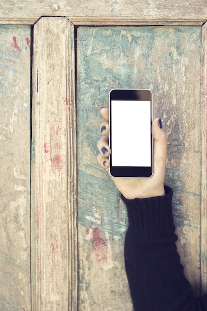 Dziewczyna z pustym telefonem komórkowym na drewnianym tle