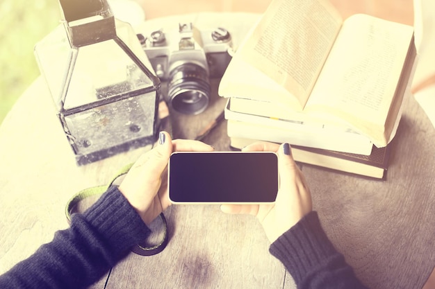Dziewczyna z pustymi książkami na telefon komórkowy i starą kamerą