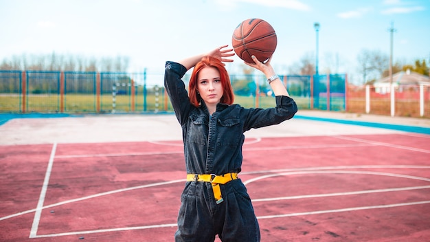 Dziewczyna z rudymi włosami na boisku do koszykówki