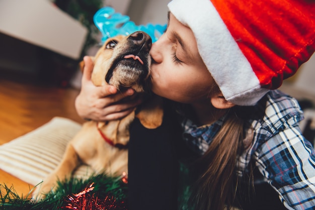 Dziewczyna Z Santa Hat Całuje Psa