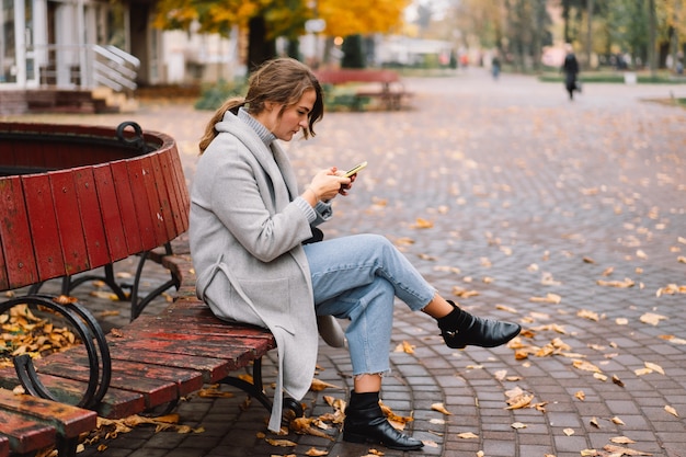 Dziewczyna za pomocą telefonu w parku. Koncepcja technologii.