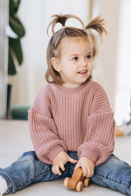 Dziewczynka bawi się zabawkami w salonie Montessori drewniana zabawka złożona piramida Koło trójkąt prostokąt drewniane elementy zabawek dla dzieci kolorowa zabawka niebieski żółty czerwony zielony