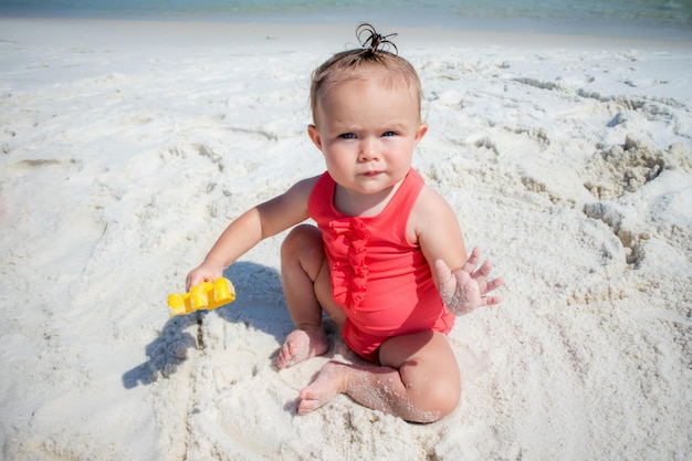 Zdjęcie dziewczynka bawiąca się na plaży.