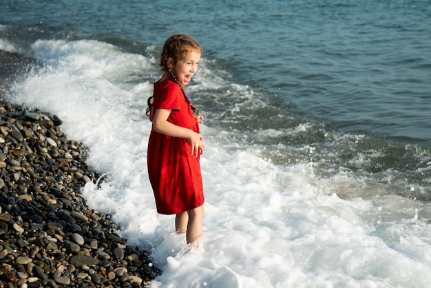 Dziewczynka od 6 lat na morzu skacze po falach i dobrze się bawi Rodzinne wakacje Dzieciństwo Lato