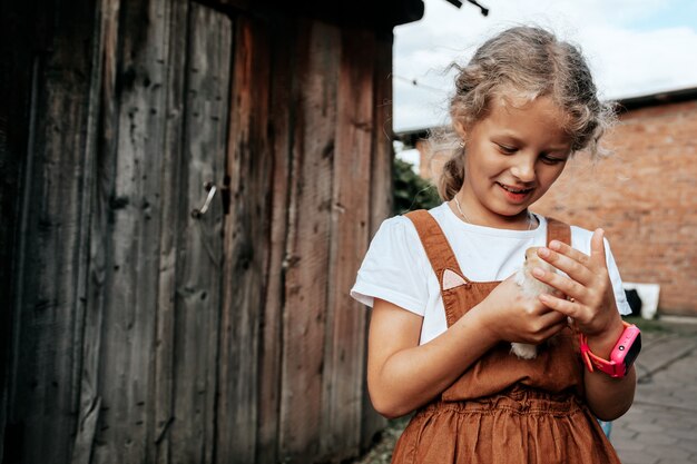 Dziewczynka Opiekuje Się Nowo Narodzonymi żółtymi Kurczakami Na Podwórku. Małe Gospodarstwo Domowe I Koncepcja Mini Zoo