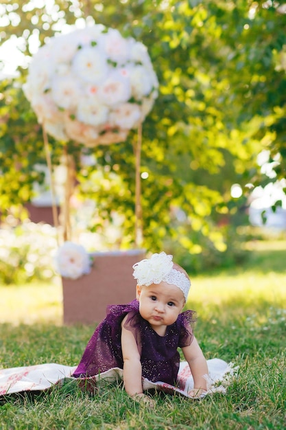 dziewczynka w fioletowej sukience bawi się w ogrodzie