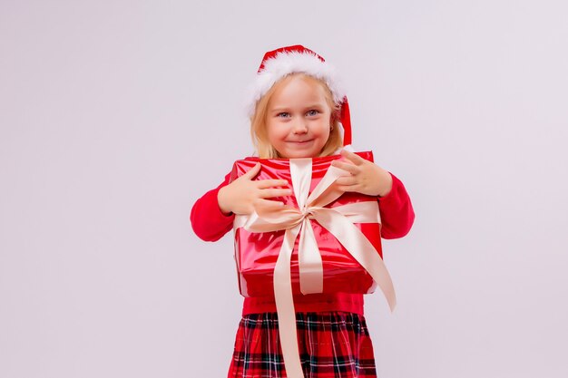 dziewczynka w Santa hat gospodarstwa czerwone pudełko na białej ścianie